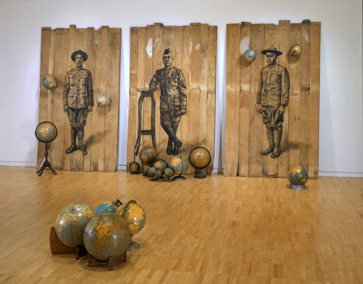 Whitfield Lovell Autour Du Monde, 2008 Conte on wood panels with globes 102 x 189 x 171 inches ©Whitfield Lovell. Courtesy of DC Moore Gallery, New York